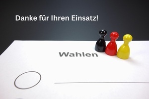 Danke für Ihren Einsatz. angedeuteter Stimmzettel und drei Spielfiguren in den Farben der deutschen Nationalflagge. Danke für Ihren Einsatz. angedeuteter Stimmzettel und drei Spielfiguren in den Farben der deutschen Nationalflagge.