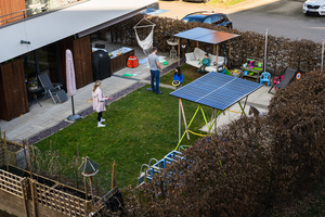 Familie spielt mit Beschattung aus Solarpanelen Familie spielt mit Beschattung aus Solarpanelen