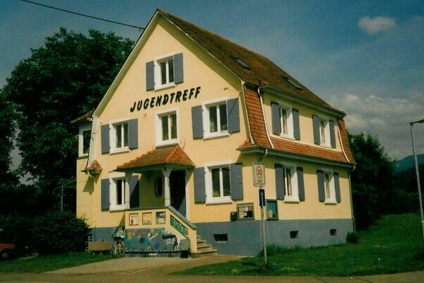 Ein älteres Foto des Jugendtreffs in der Hindenburgstraße. Für eine detailreiche Bildbeschreibung wählen Sie die Reisekarte “Barrierefreiheit” und suchen Sie nach der Überschrift “Vergilbter Jugendtreff”.